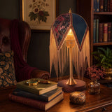 mid-century tassel table lamp glowing on a bedside table