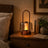portable lantern-style ambient table lamp glowing on a bedside table