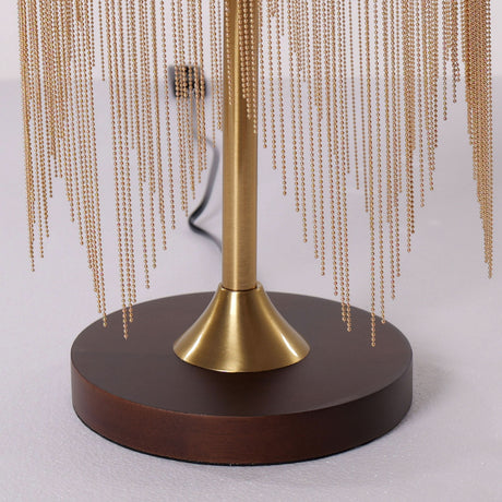 mid-century tassel table lamp glowing on a bedside table