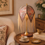 mid-century tassel table lamp on a desk with soft ambient light